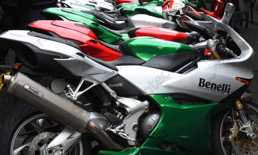 CT002841 
 Bristol Italian Motor Show, line of Benelli motor bikes 
 Keywords: cars, Italian, street views, motor bikes, Benelli, colourful, wetdays, rain, red, green, white